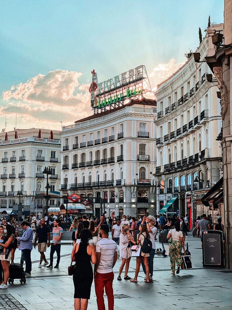 Puerta del Sol square in Madrid, Spain. The photo was taken in the middle of the Covid 19 epidemic because some people are wearing masks. The square is lively. The weather looks pleasant.