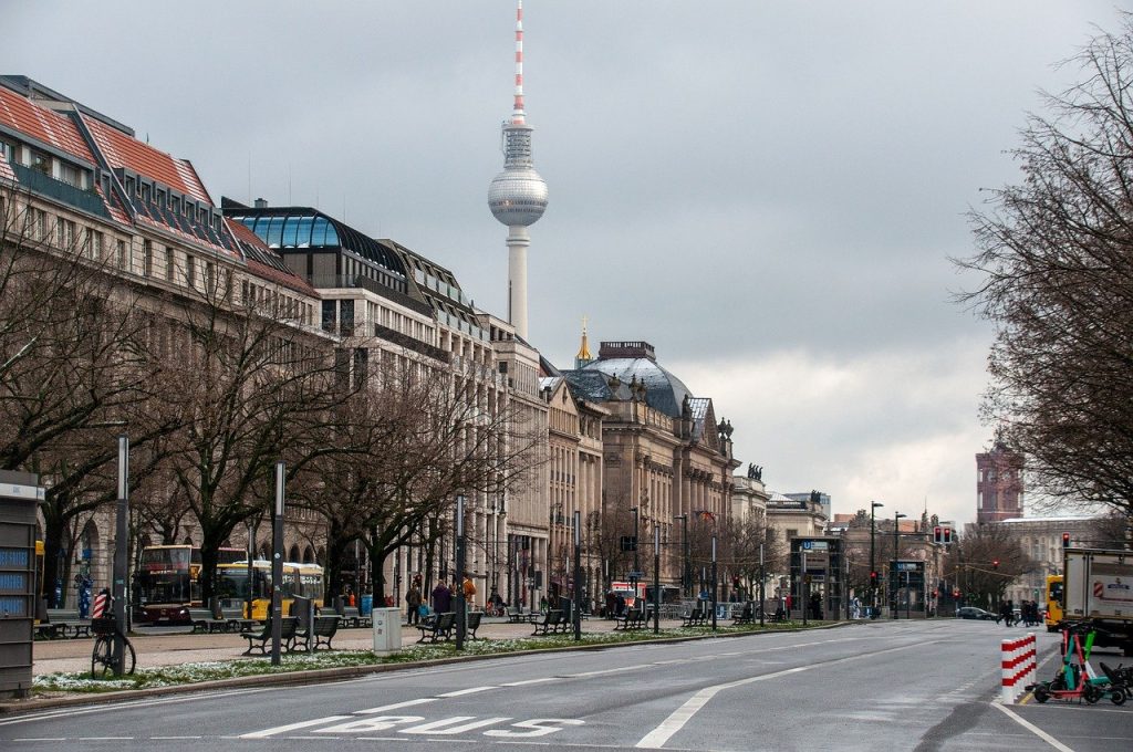 Photo of a street near the television tower in Berlin. The weather is grey and the street is empty of people.