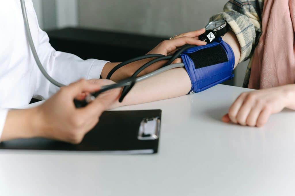During a medical consultation, the doctor takes the patient's blood pressure using a blood pressure monitor.